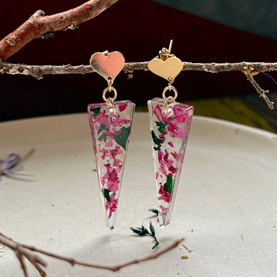 Zoom de par de aros Caldera con petalos de hortensia rosada y hojitas verdes encapsuladas