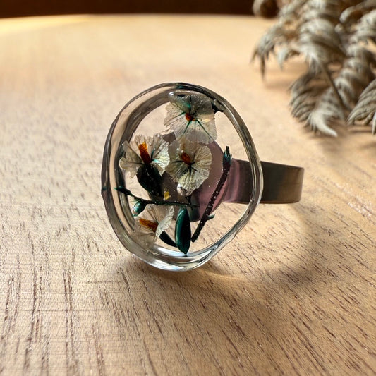 Vista lateral de capsula de resina transparente con flores de anillo Meulin.