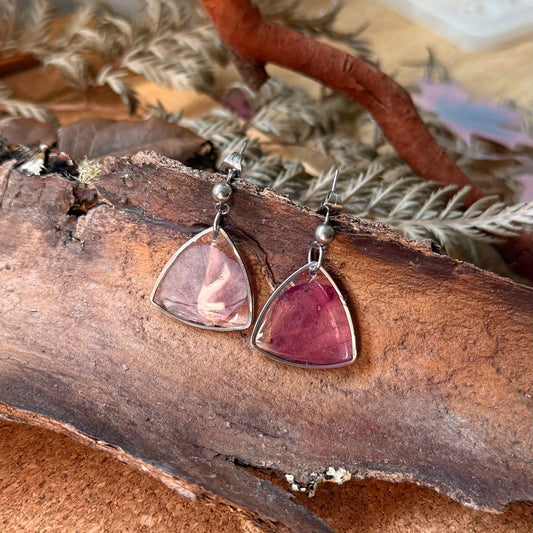 Par de aros Futrono, forma tringular que encapsula pétalo de hortensia morada.