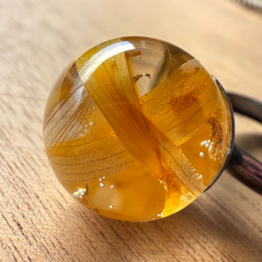 Zoom de anillo Quellón con cápsula esferica y pétalos de girasol.