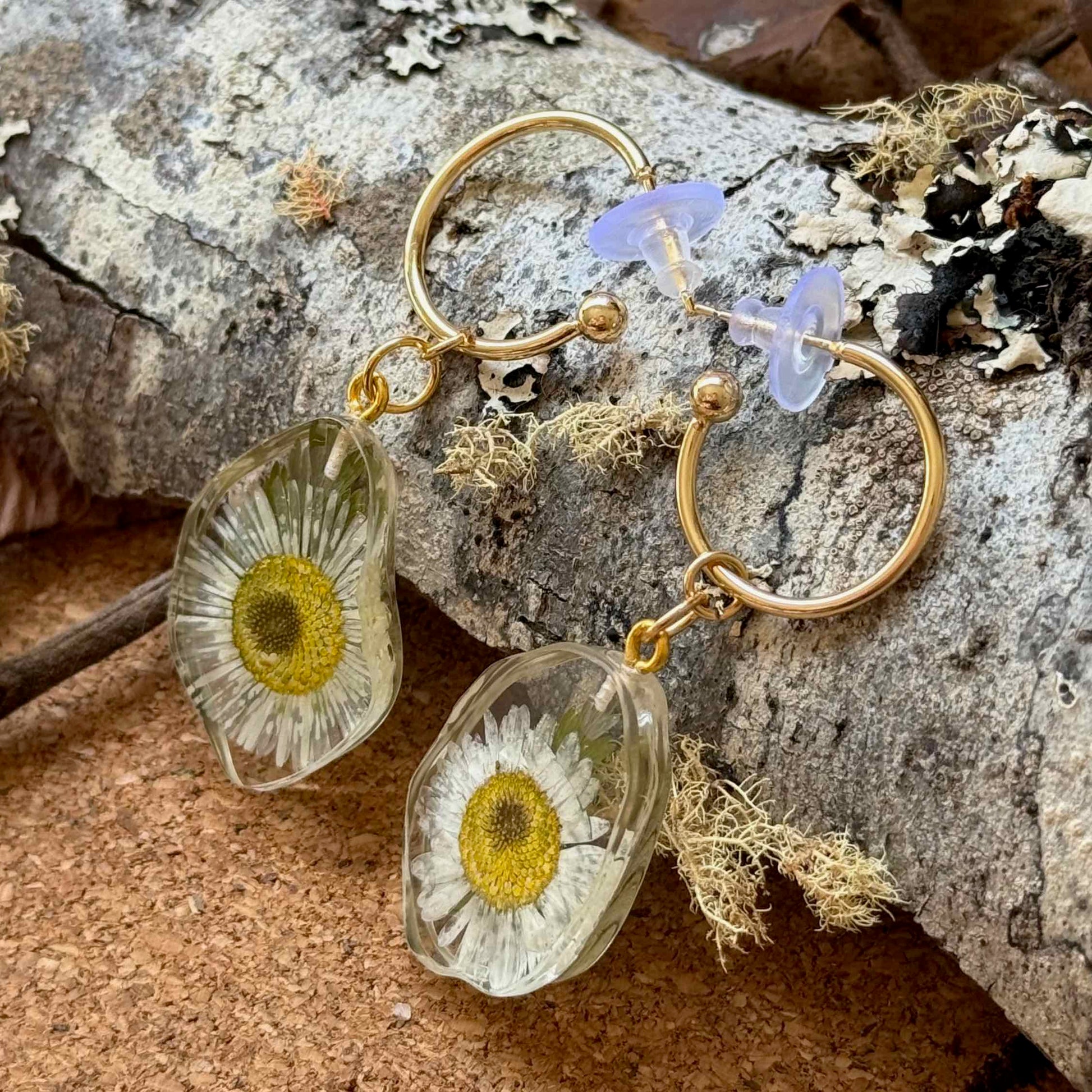 Vista lateral del par de aros Frutillar con flor margarita
