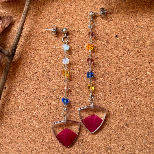 Par de aros Ruminano, cadena con mostacillas de colores, cápsula de resina con pétalo de bugambilia rosada.