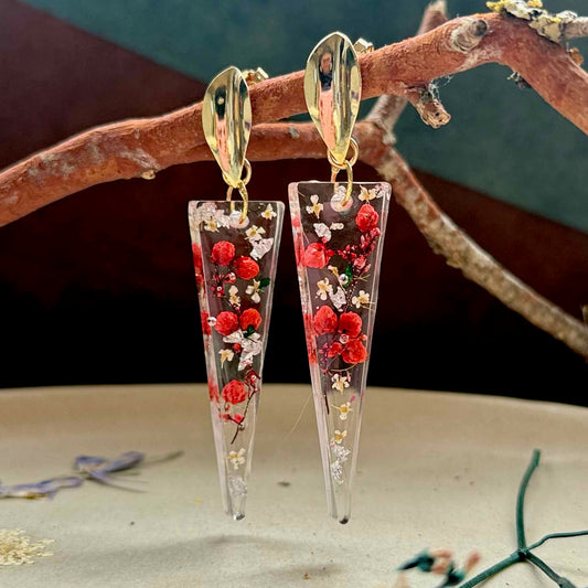 Par de aros Pucura, cápsula de resina triangular con flor de arroz roja encapsulada.