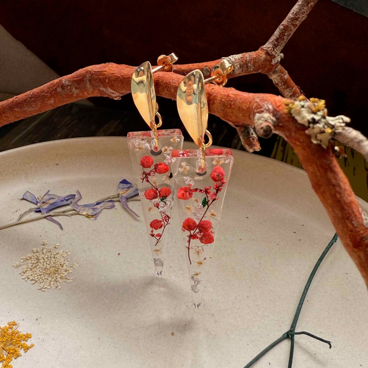 Otra vista de Par de aros Pucura con flor de arroz roja y miniflores de cicuta