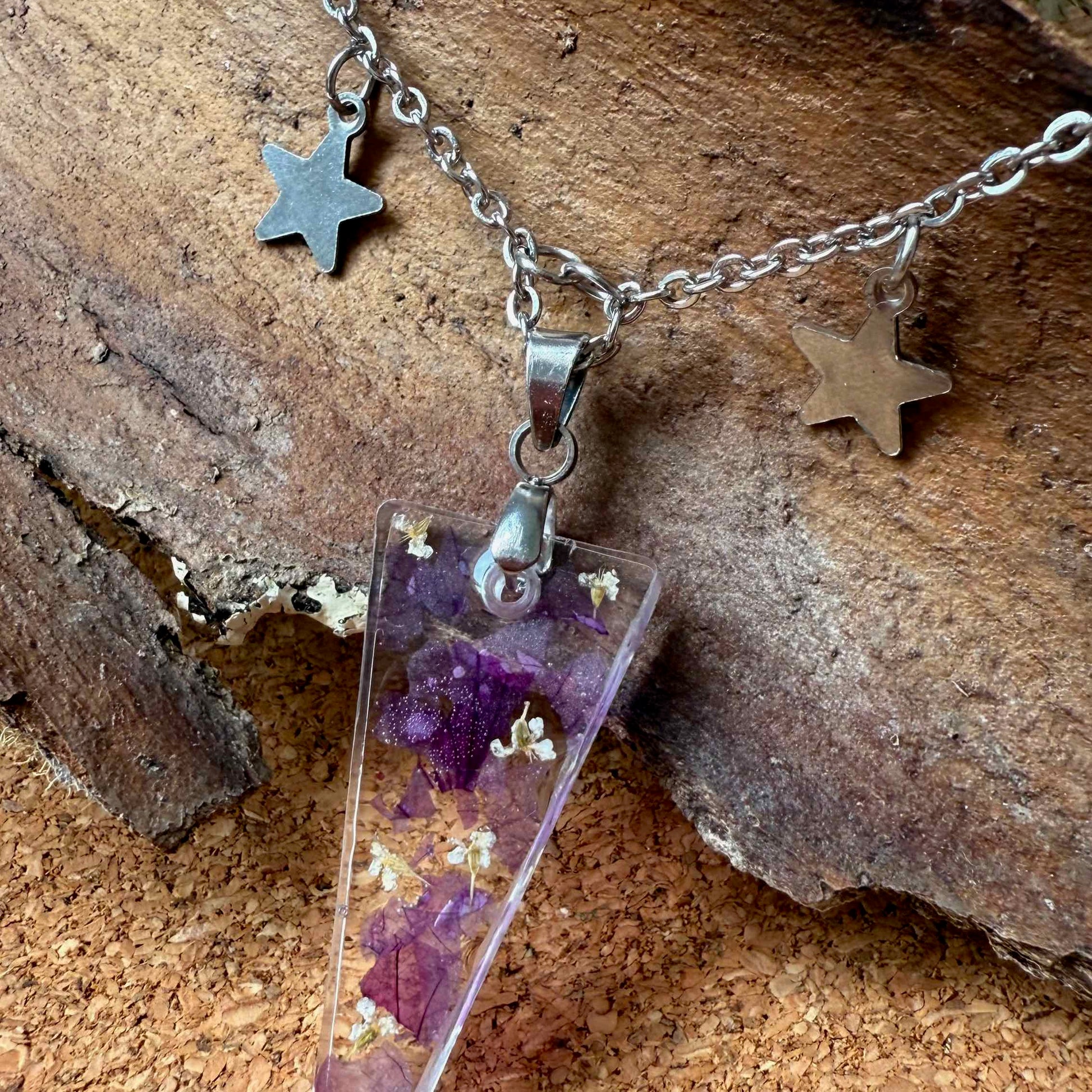 Zoom de collar Pichilemu de acero con forma triangular y dos estrellitas de acero colgando en la cadena