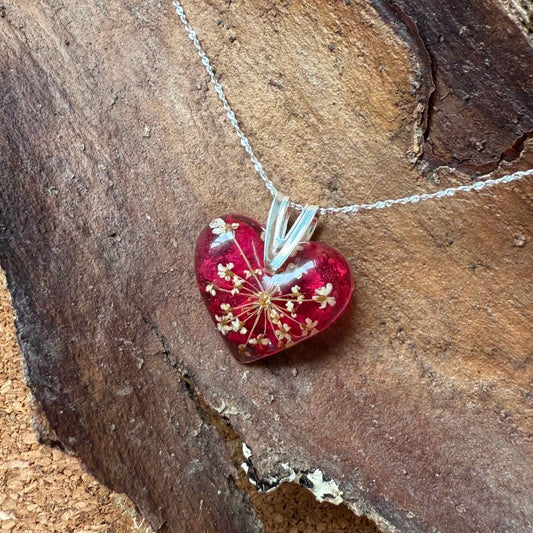 Collar Licán Ray con forma de corazón, con pétalo de bugambilia y mini flor de cicuta.