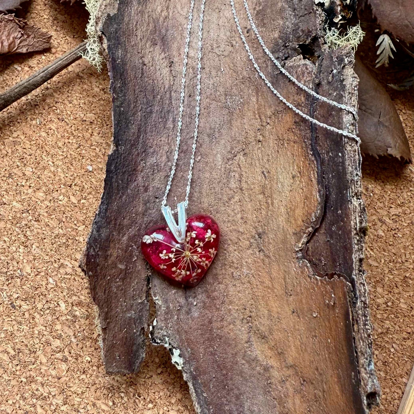 Collar Licán Ray con forma de corazón, con pétalo de bugambilia y mini flor de cicuta.