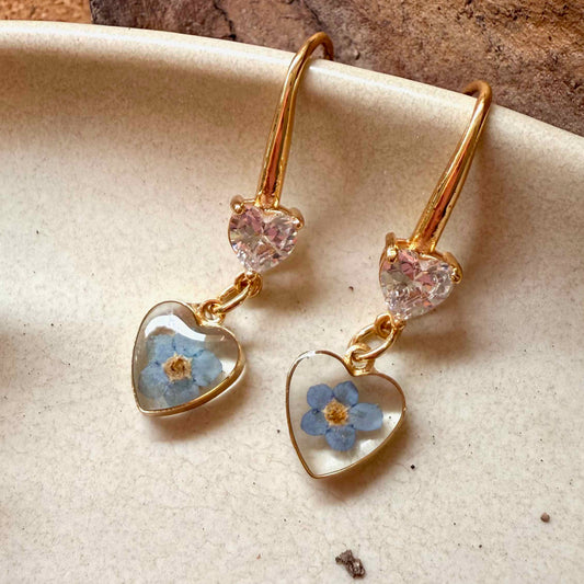 Zoom a flor no me olvides color celeste en   par de aros Bolsón