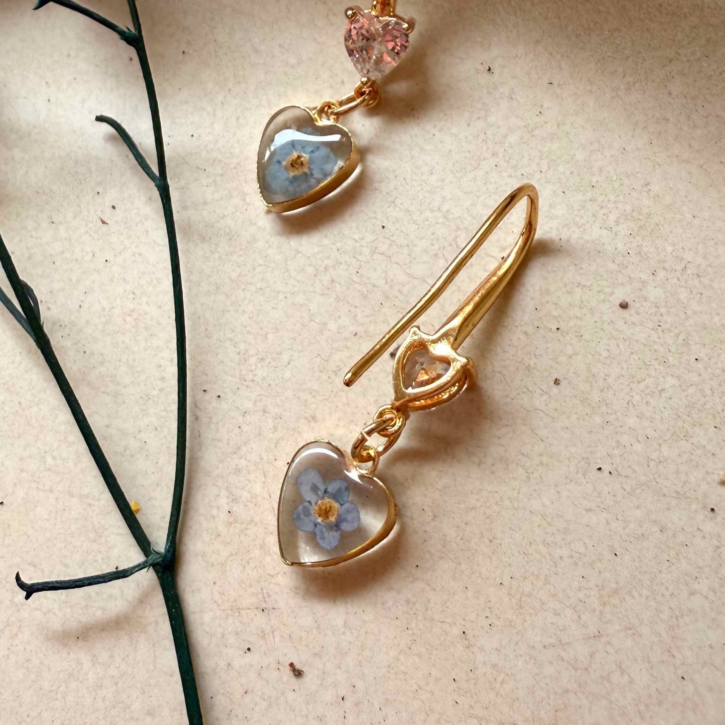 parte posterior de aros Bolsón com flor celeste no me olvides.